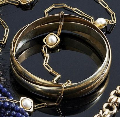 TROIS BRACELETS rigides entrelacés en or...