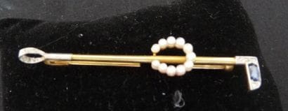 BROCHE stylisant un maillet de polo en ors...