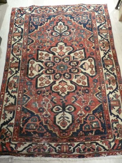DEUX TAPIS en laine L'un à fond rouge à motif...