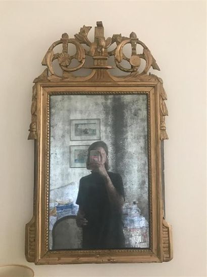 MIROIR en bois et stuc dorés, le fronton...