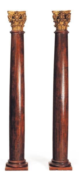 Deux colonnes en bois teinté et doré, à chapiteaux...