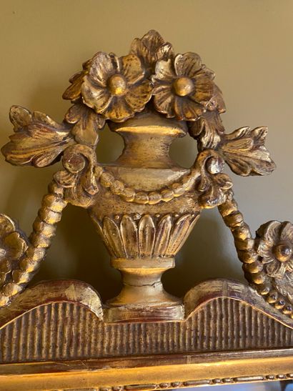 Gilded wood mirror surmounted by a flowering...