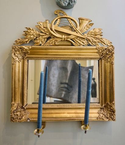 Gilded wood mirror, topped by a carved and...