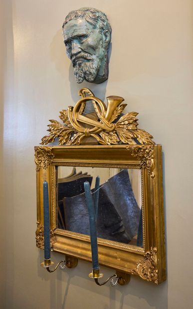 Gilded wood mirror, topped by a carved and...