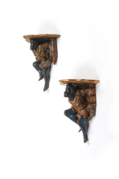 A pair of Nubian-style wall sconces, carved...