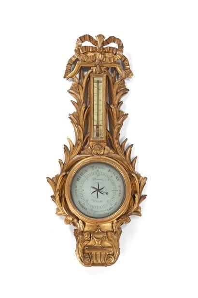 A richly carved and gilded wooden barometer...