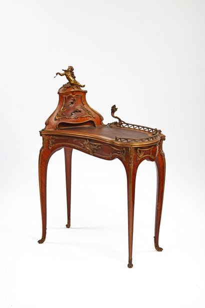 A rosewood writing desk with an undulating...