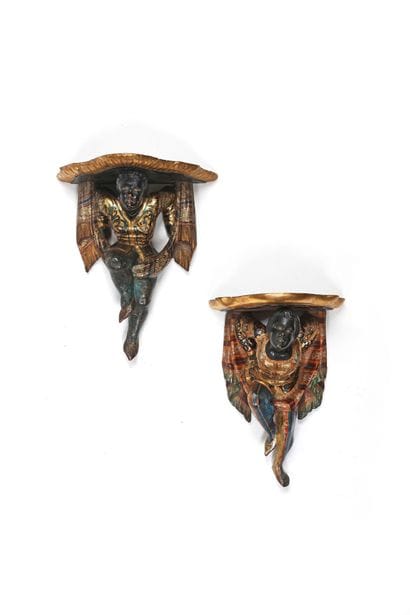 A pair of Nubian-style wall sconces, carved...