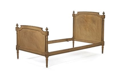 Bed frame made of carved wood with a cream...