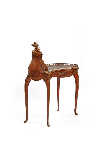 A rosewood writing desk with an undulating...