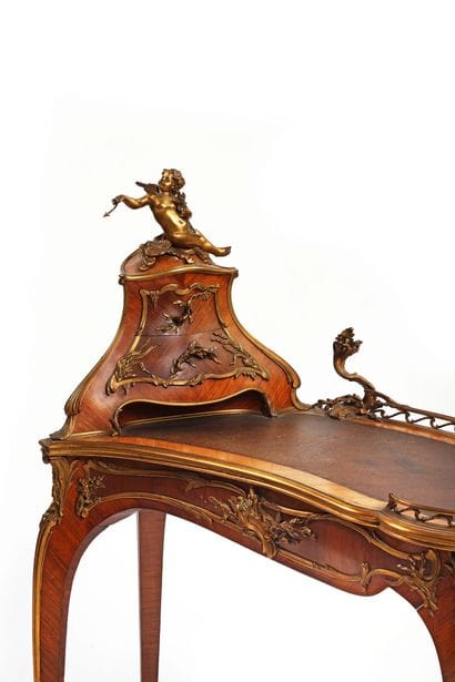 A rosewood writing desk with an undulating...