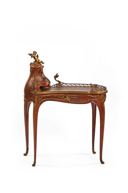 A rosewood writing desk with an undulating...