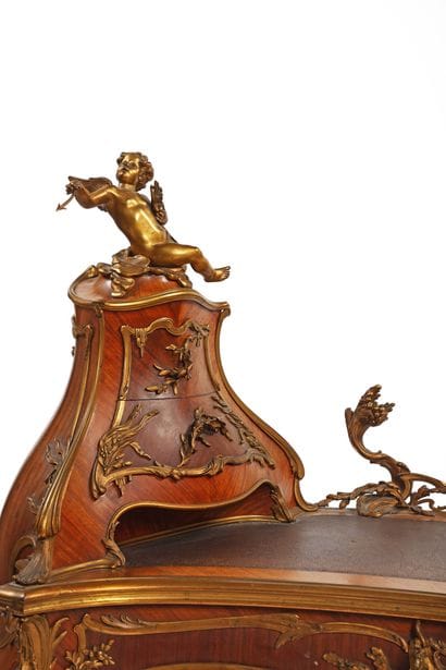 A rosewood writing desk with an undulating...