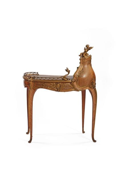 A rosewood writing desk with an undulating...
