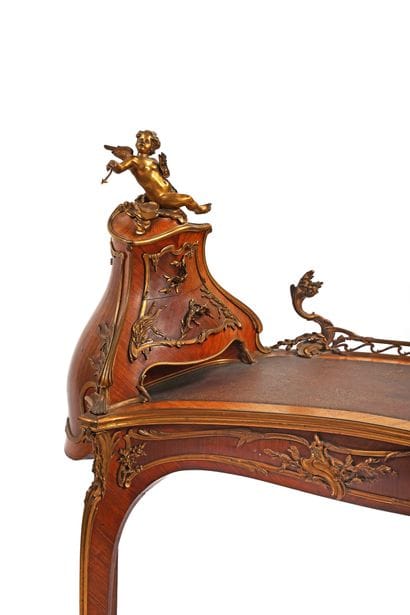 A rosewood writing desk with an undulating...