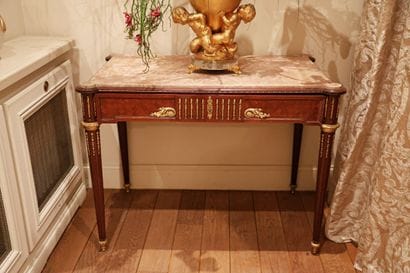Wood veneer table resting on four tapered,...