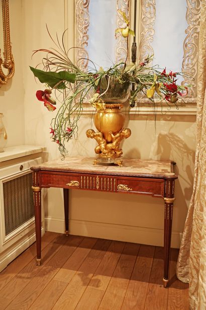 Wood veneer table resting on four tapered,...