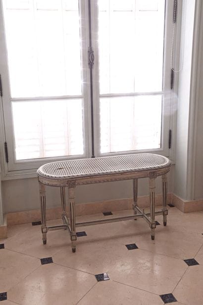 A bench with rounded ends, made of cream-lacquered...