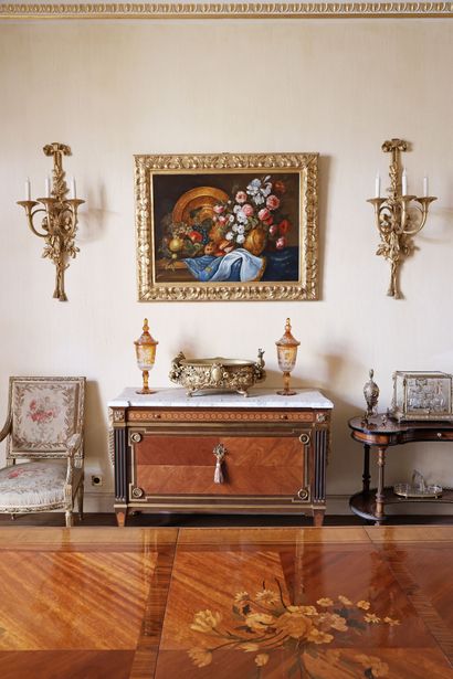A veneered wood chest of drawers featuring...