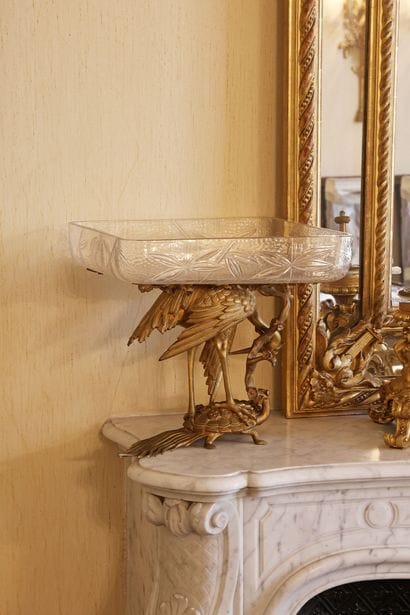 A cut-glass goblet resting on a gilded bronze...