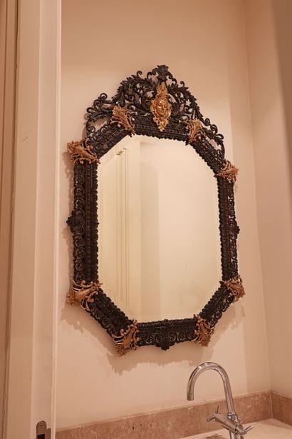 Octagonal mirror in patinated bronze, decorated...