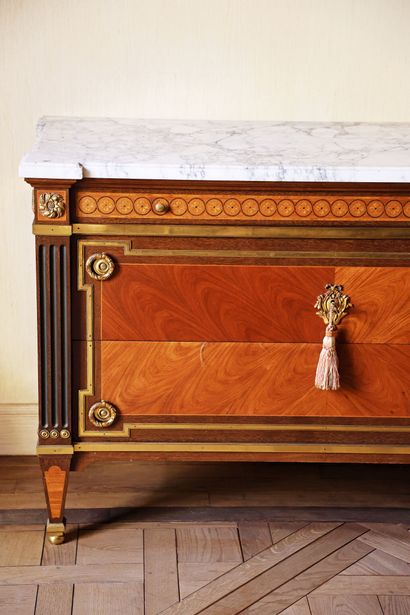 A veneered wood chest of drawers featuring...