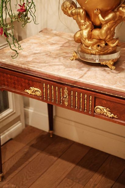 Wood veneer table resting on four tapered,...