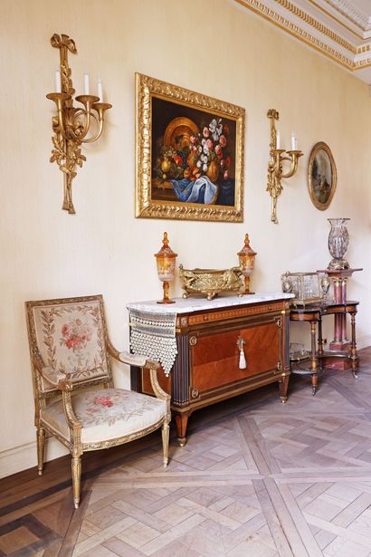 A veneered wood chest of drawers featuring...