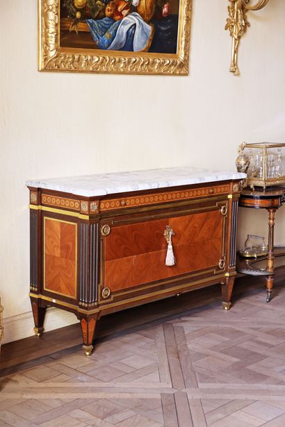 A veneered wood chest of drawers featuring...