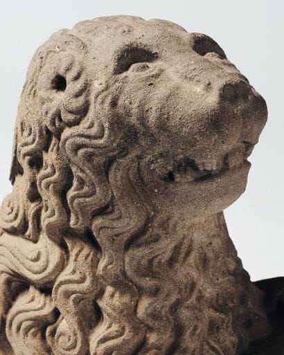 Lion sculpté en pierre bleue tenant un cartouche...