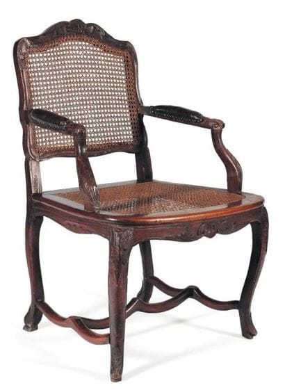 Fauteuil canné et sculpté de feuillages,...