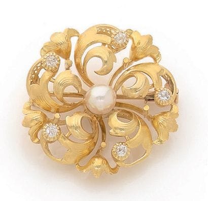 BROCHE en or jaune 18K (750) ajourée de rinceaux...