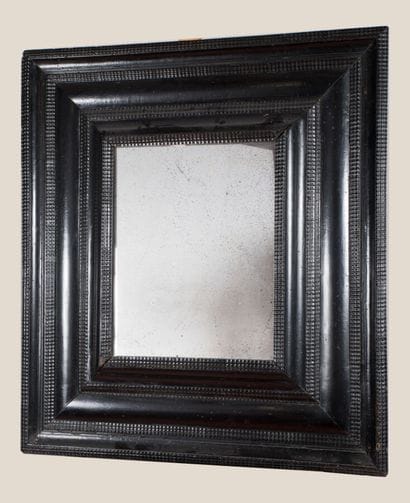 Grand miroir à profil renversé, en bois noirci,...