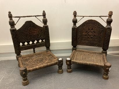 Set of two low chairs in carved wood, the...