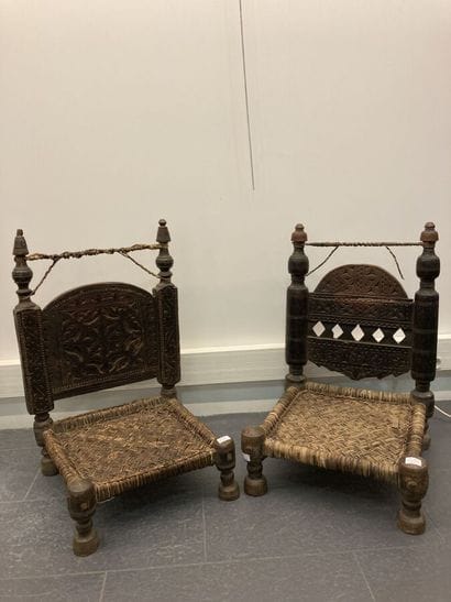 Set of two low chairs in carved wood, the...