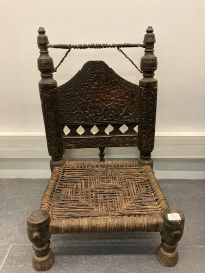 Set of two low chairs in carved wood, the...