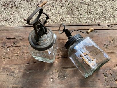 Two glass, metal and wood butter churns holding...