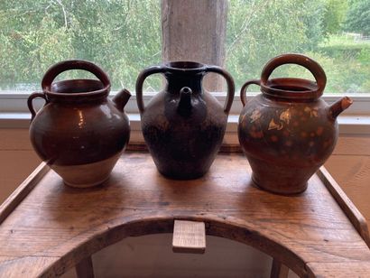 Three glazed earthenware jugs with brown...