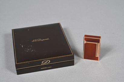 S.T. DUPONT.
Briquet en métal doré et laque...