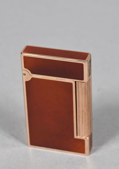 S.T. DUPONT.
Briquet en métal doré et laque...