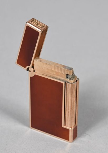 S.T. DUPONT.
Briquet en métal doré et laque...