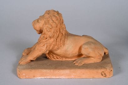 Lion couché sur une terrasse en terre cuite....