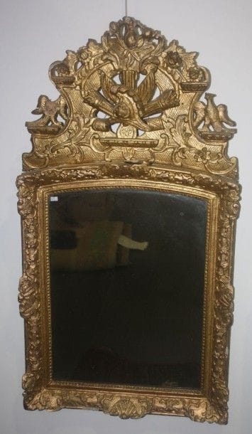 Miroir en bois sculpté et doré surmonté d'un...
