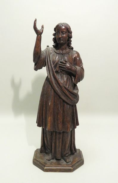 Ange en bois sculpté. Debout, il lève son...