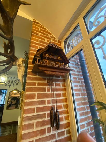 Carved wooden cuckoo clock with a chalet...