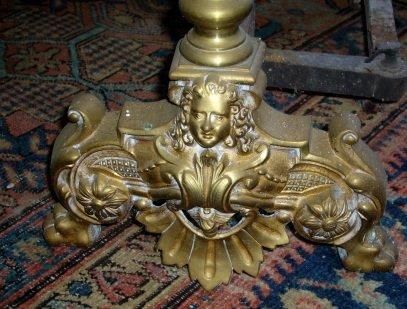 Paire de chenets en laiton doré.Deux pieds...