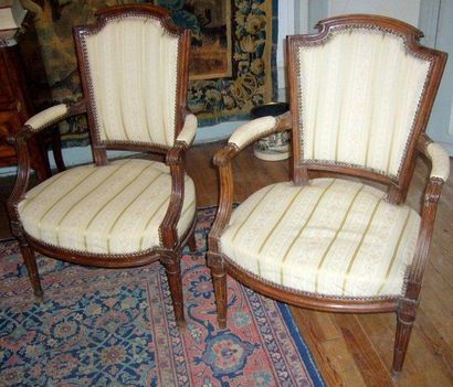 Deux fauteuils appariés en noyer. Pieds fuselés,...