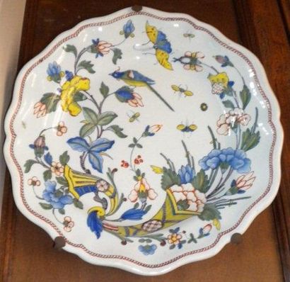 Un plat rond festonné en faïence de Rouen.Décor...