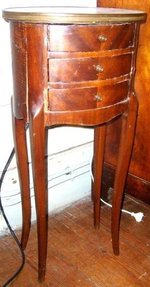 Petite table chiffonnière ovale en acajou.Quatre...
