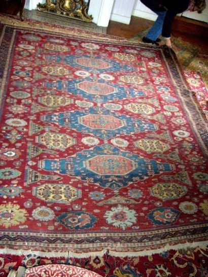 Rare tapis en laine Heriz. Fond rouge à décor...